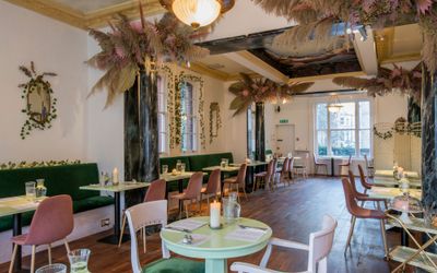 interior at in Hove cafe for an Oeuf experience. Decorated with dried flowers and brightly painted furnishings in pastel green.