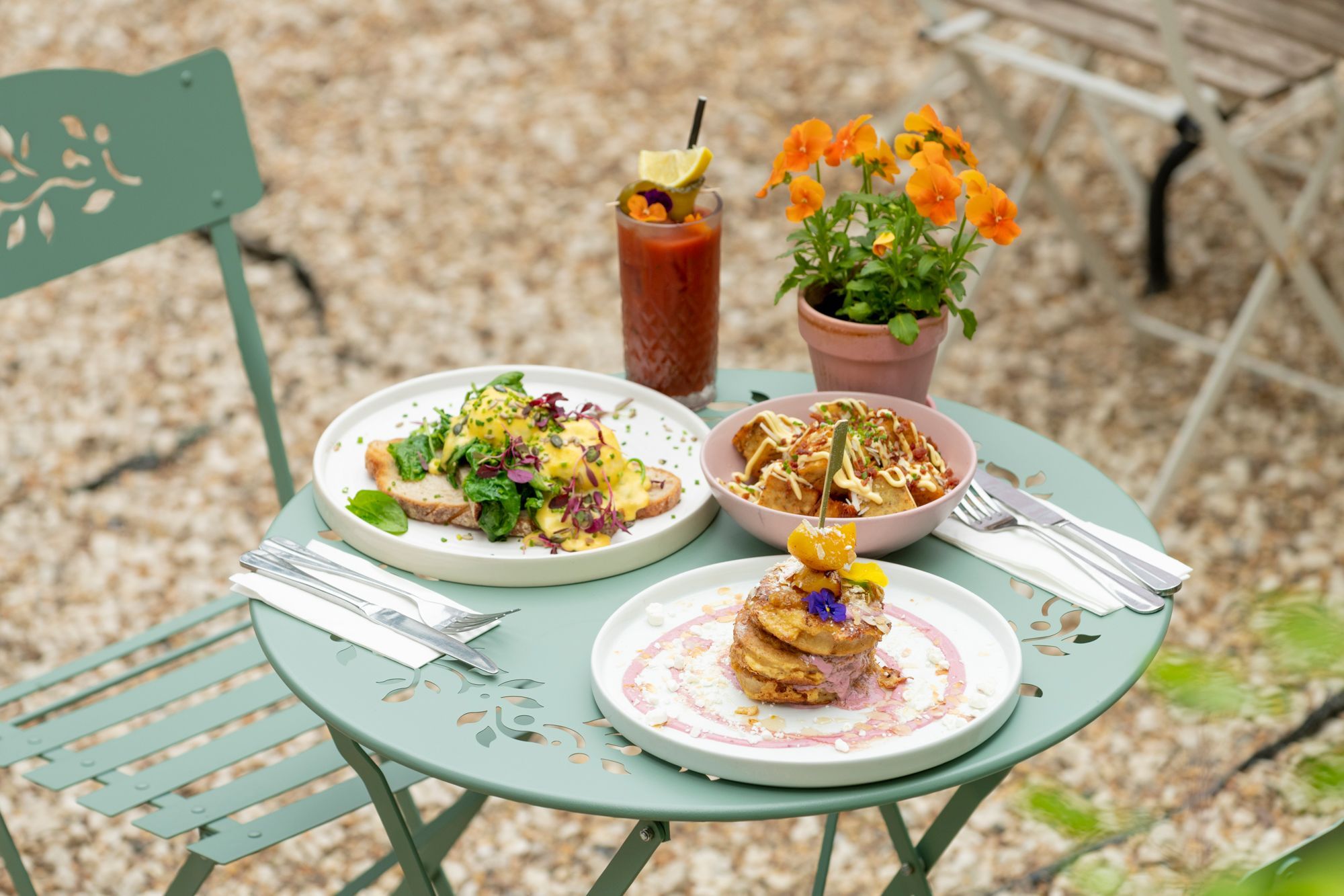 over head shot of the light green table and chairs in the Oeuf garden in Hove. Delicious breakfast dishes served with drinks