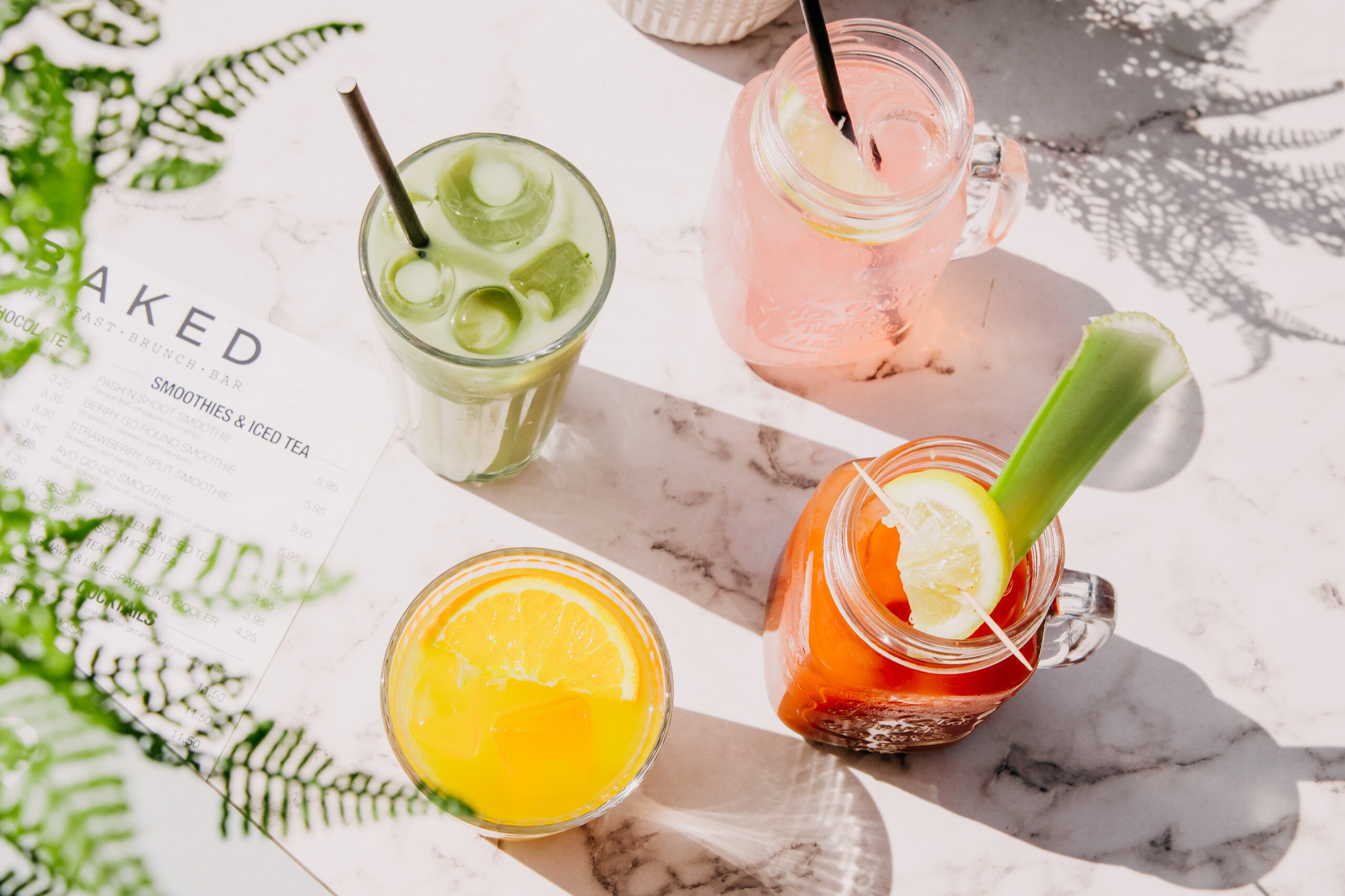 over head shot of juices and cocktails served on table at baked Hove