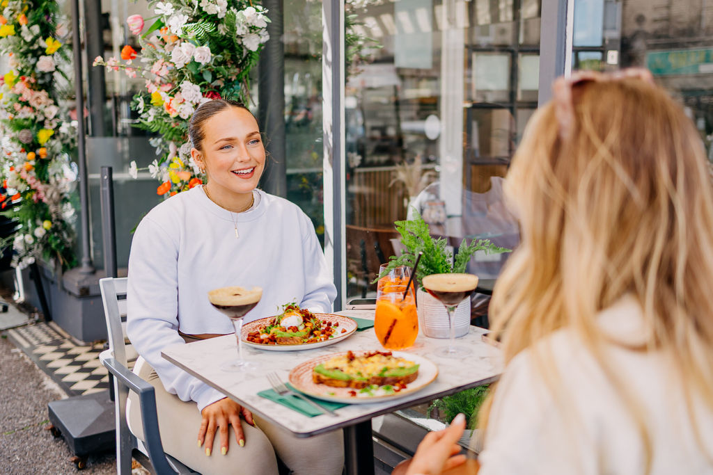 two girls enjoying bottomless brunch at baked in Hove. espresso Martini, sat on south facing terrace