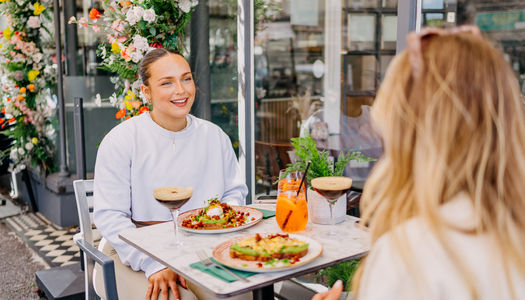 two girls enjoying bottomless brunch at baked in Hove. espresso Martini, sat on south facing terrace