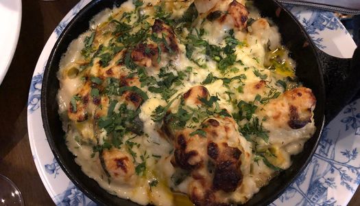 a skillet of charred cauliflower cheese