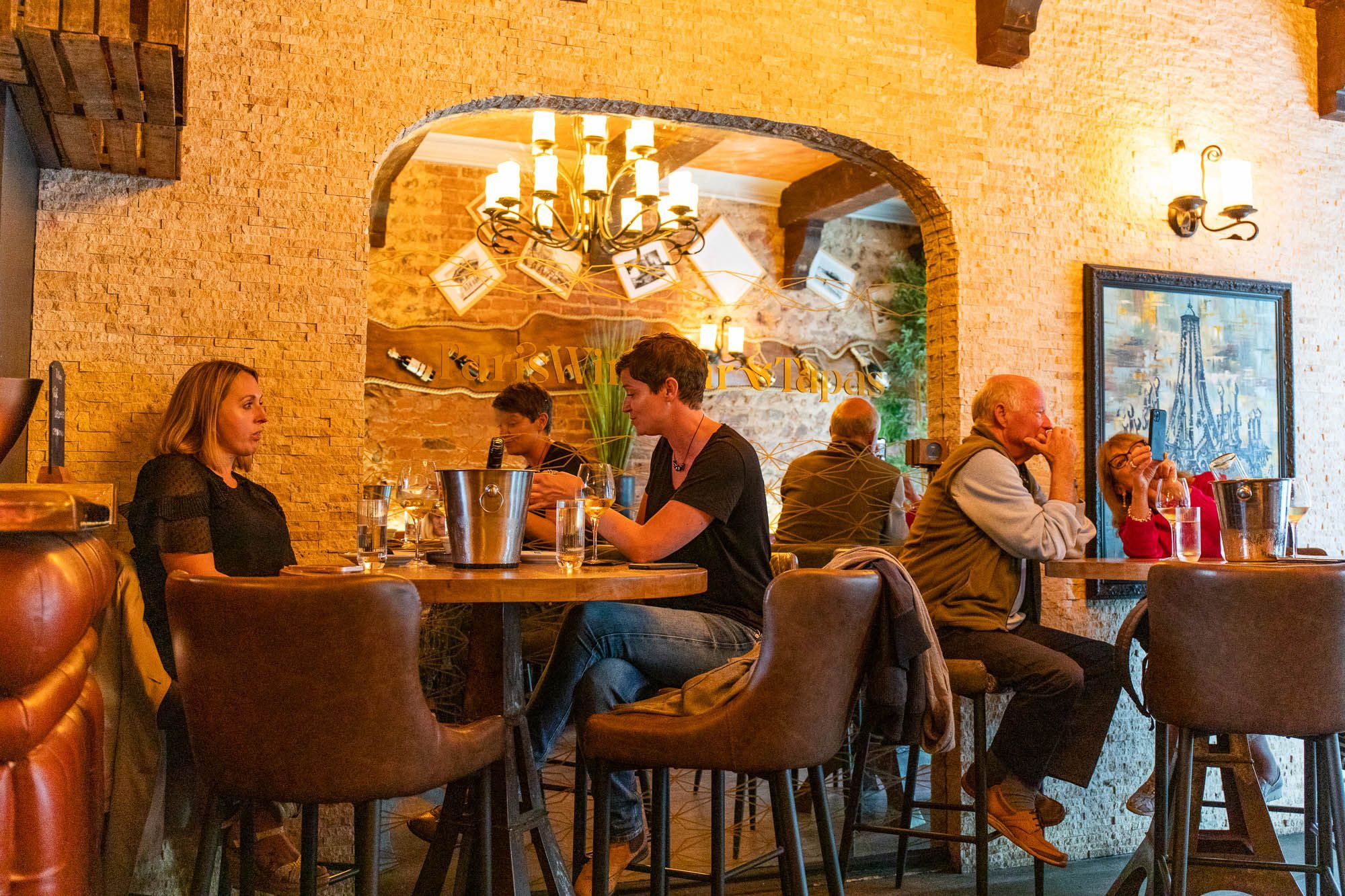 people sitting inside the paris wine bar in hove