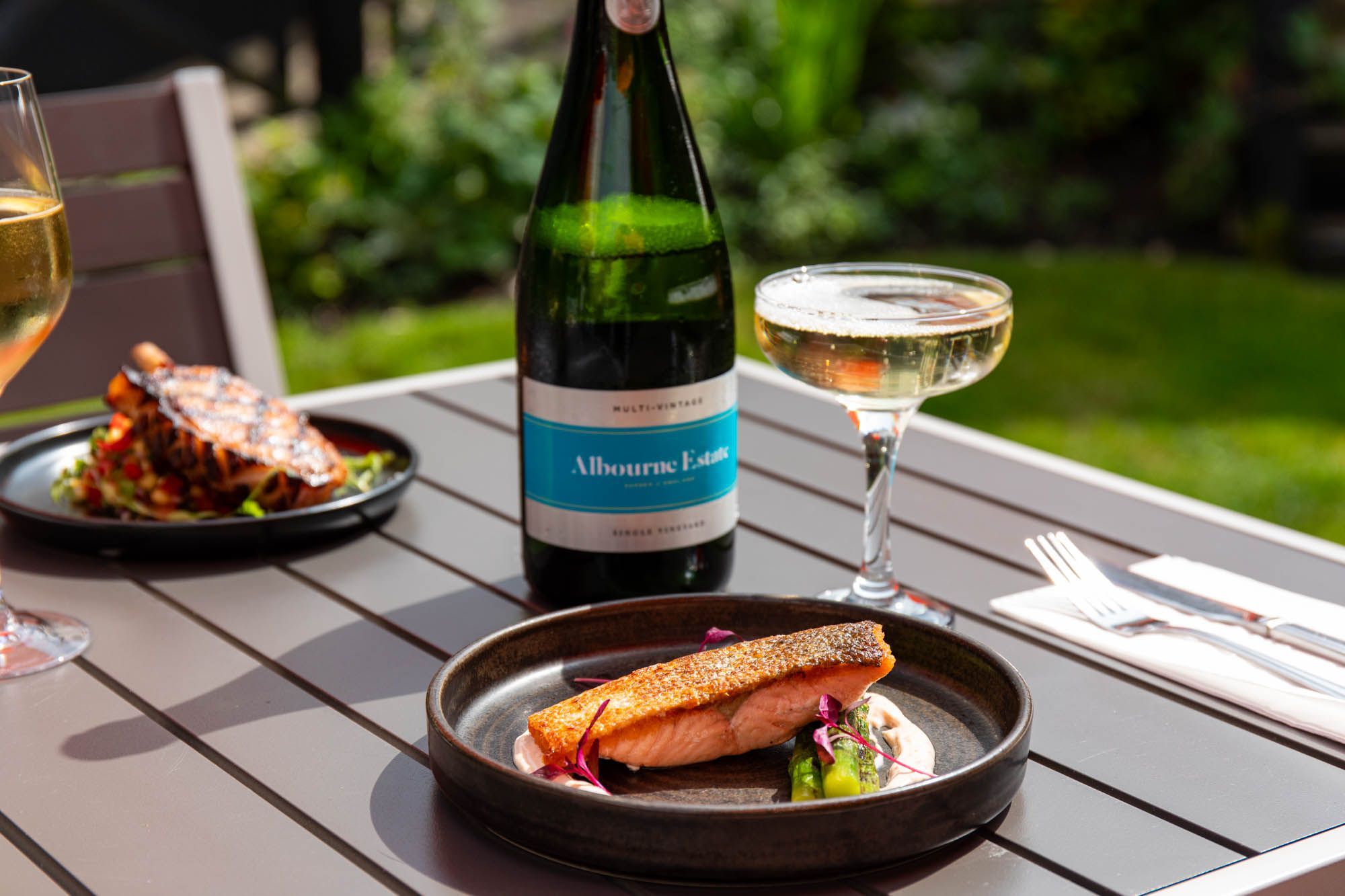 outdoor shot of the salmon dish served with glass of Albourne wine