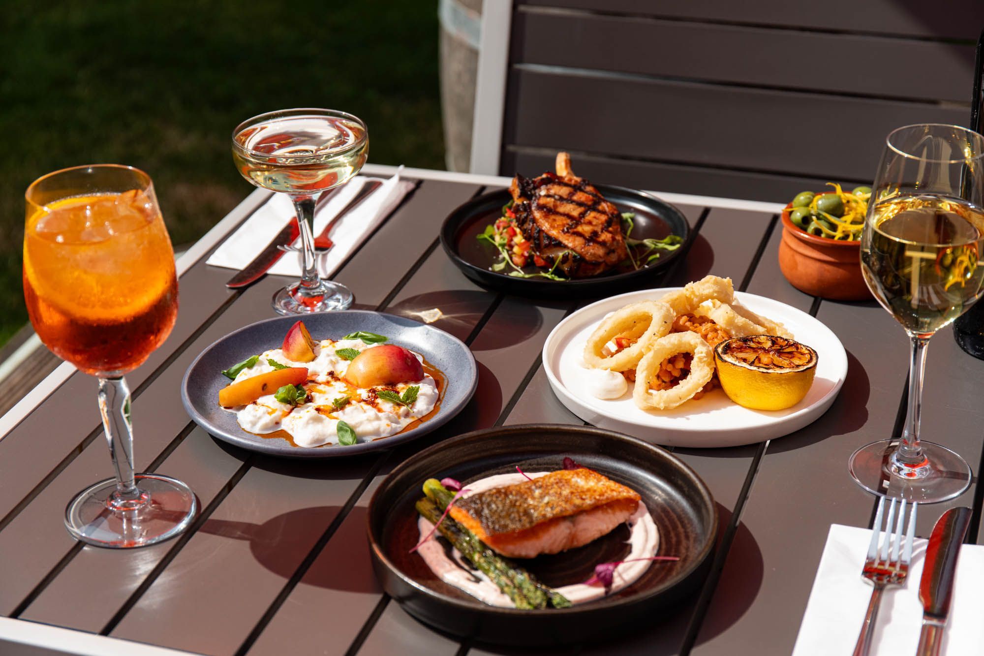 side shot of the table laid out with couple of sharing plates at the DaddyLonglegs. Food is served with different drinks