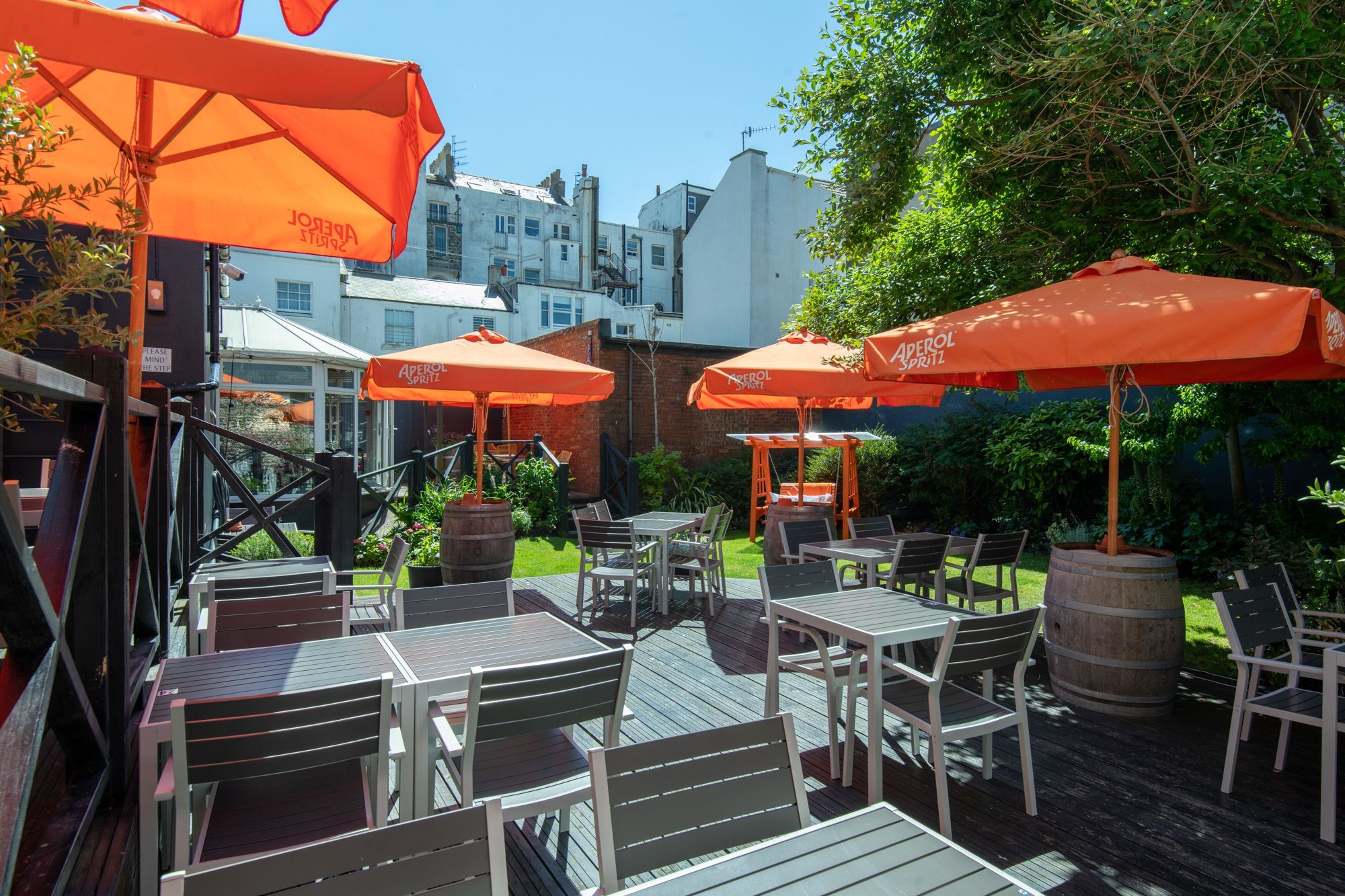 beautiful beer garden at daddylonglegs, grey chairs and tables, orange parasols