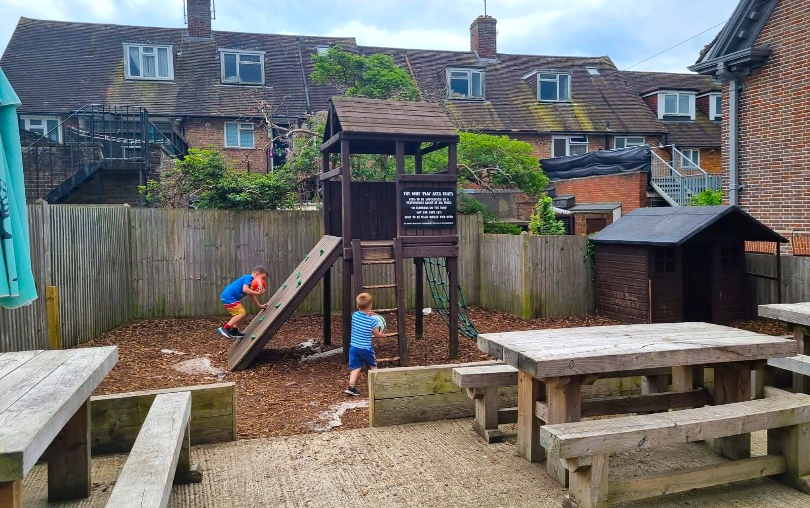 two kids playing on the kids playground in the garden during family day out at Ladies Mile