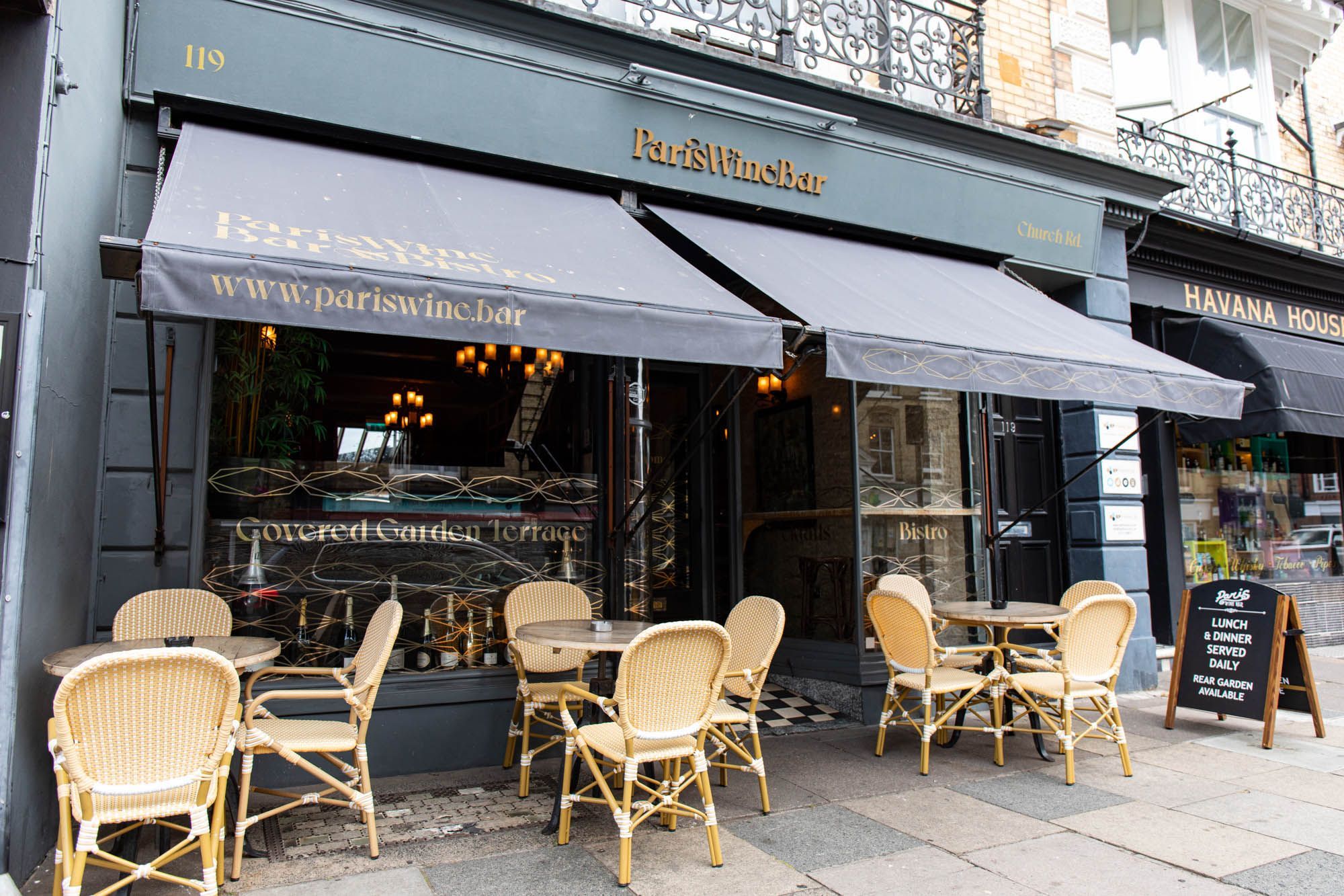 exterior shot of the Paris Wine bar - light brown wooden chairs and tables
