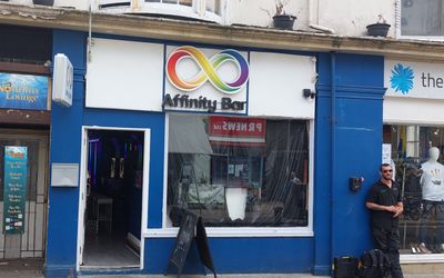 Affinity Bar Brighton A blue fronted bar with a rainbow affinity symbol over the window and a door to the left