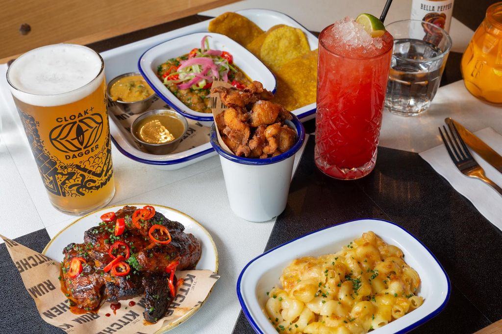 side shot of the table laid out with Caribbean dishes and cocktails