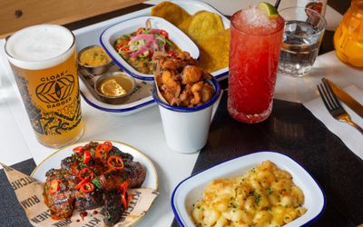 side shot of the table laid out with Caribbean dishes and cocktails