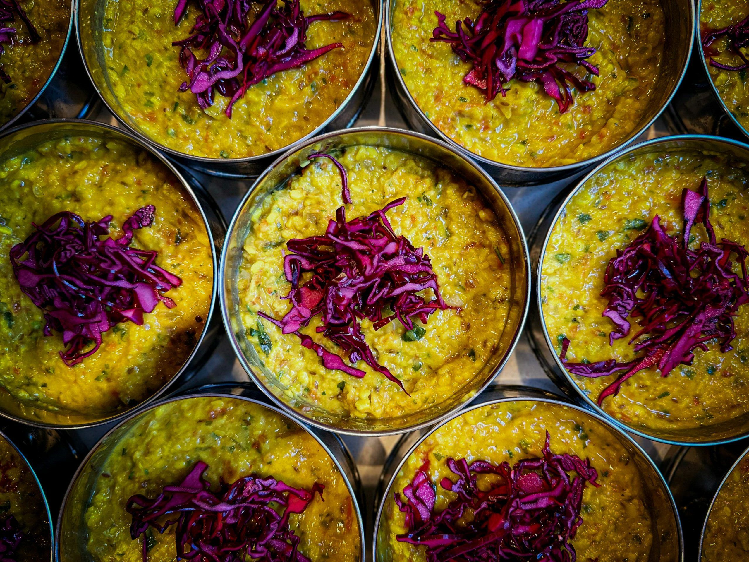 over head shot of the Majahma dishes served in tiffins