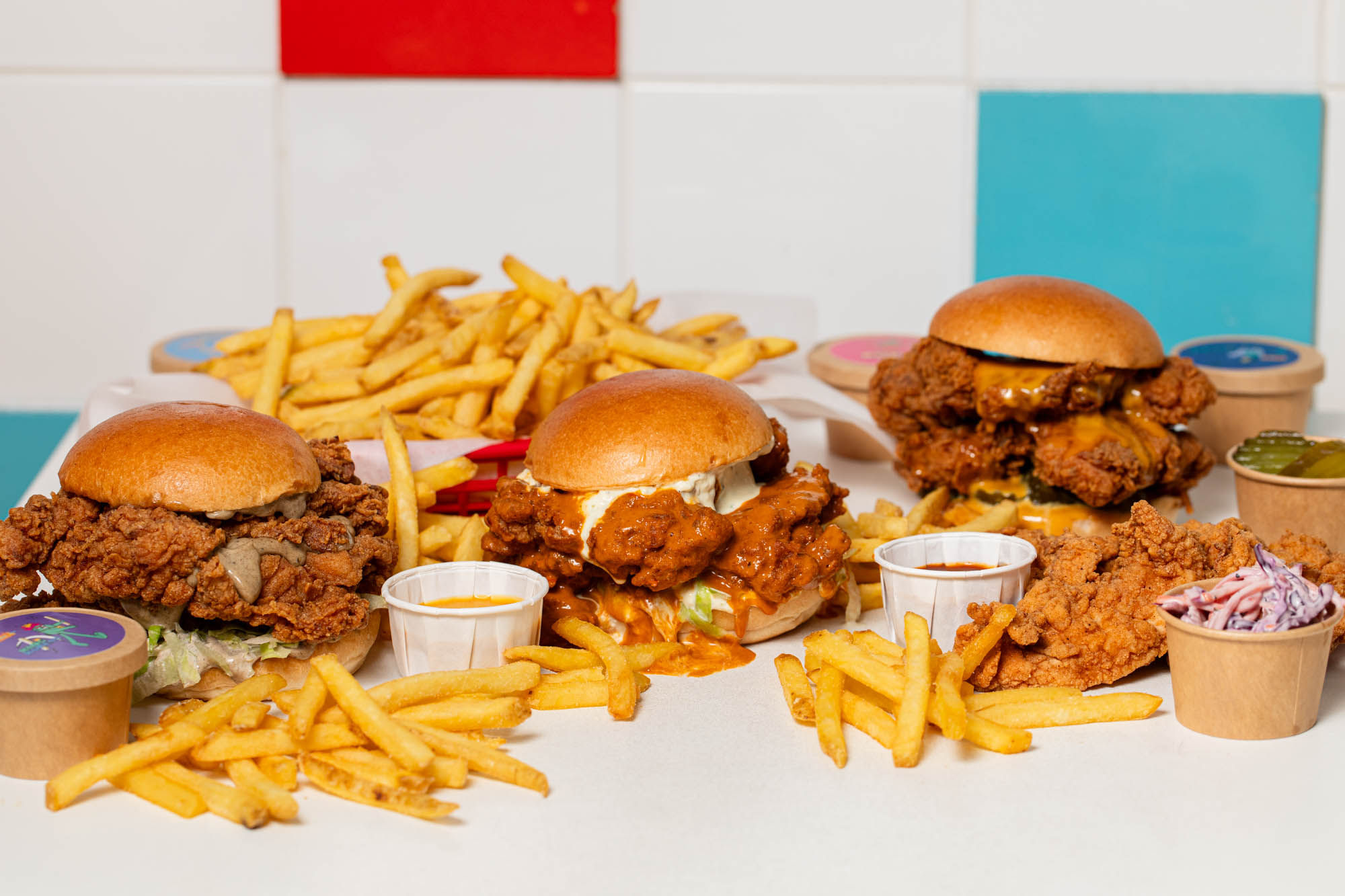 white table filled with fries, chicken burgers, and sauces at Lost Boys Land