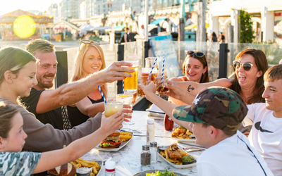 family by the table on the terrace having a toast, sunset in the background, Ohso is available for private dining Brighton or private hire