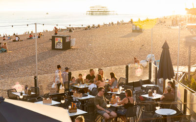 sunset shot of the ohsos outdoor terrace and Brighton beach. Coronation 2023 events here.