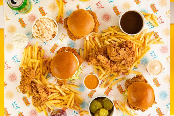 over head shot of the Lost Boys Land table with three chicken burgers, fries and sauces