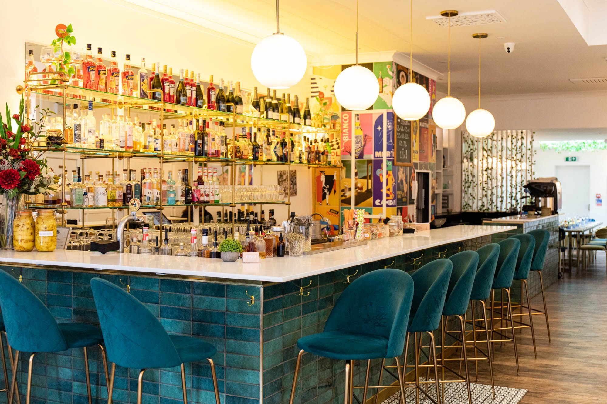 bar area of the Pesca Trattoria, velvet blue chairs and big range of alcohol drinks