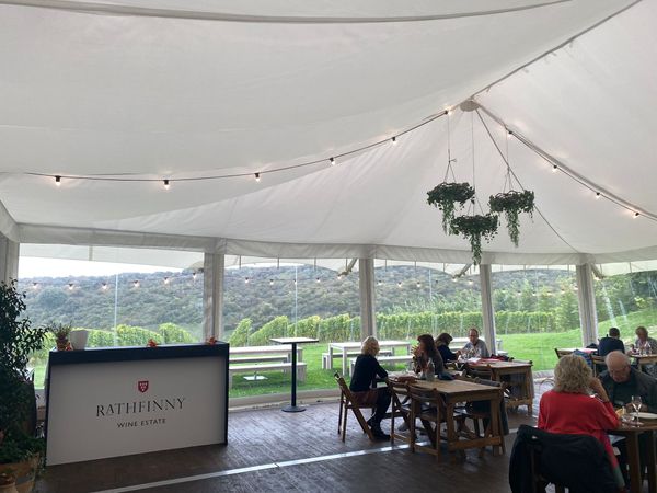 Diners inside a marquee overlooking a vineyard