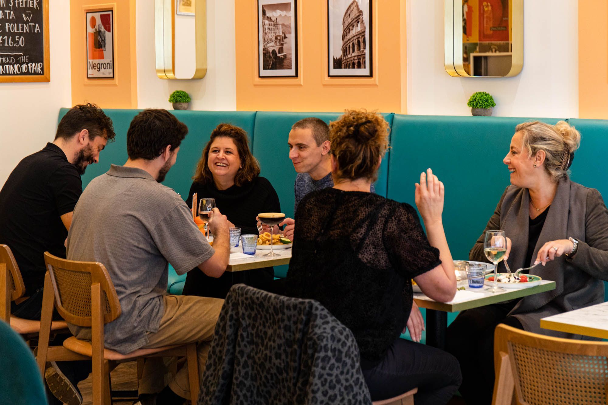 group of people enjoying their food and drinks at Pesca Trattoria