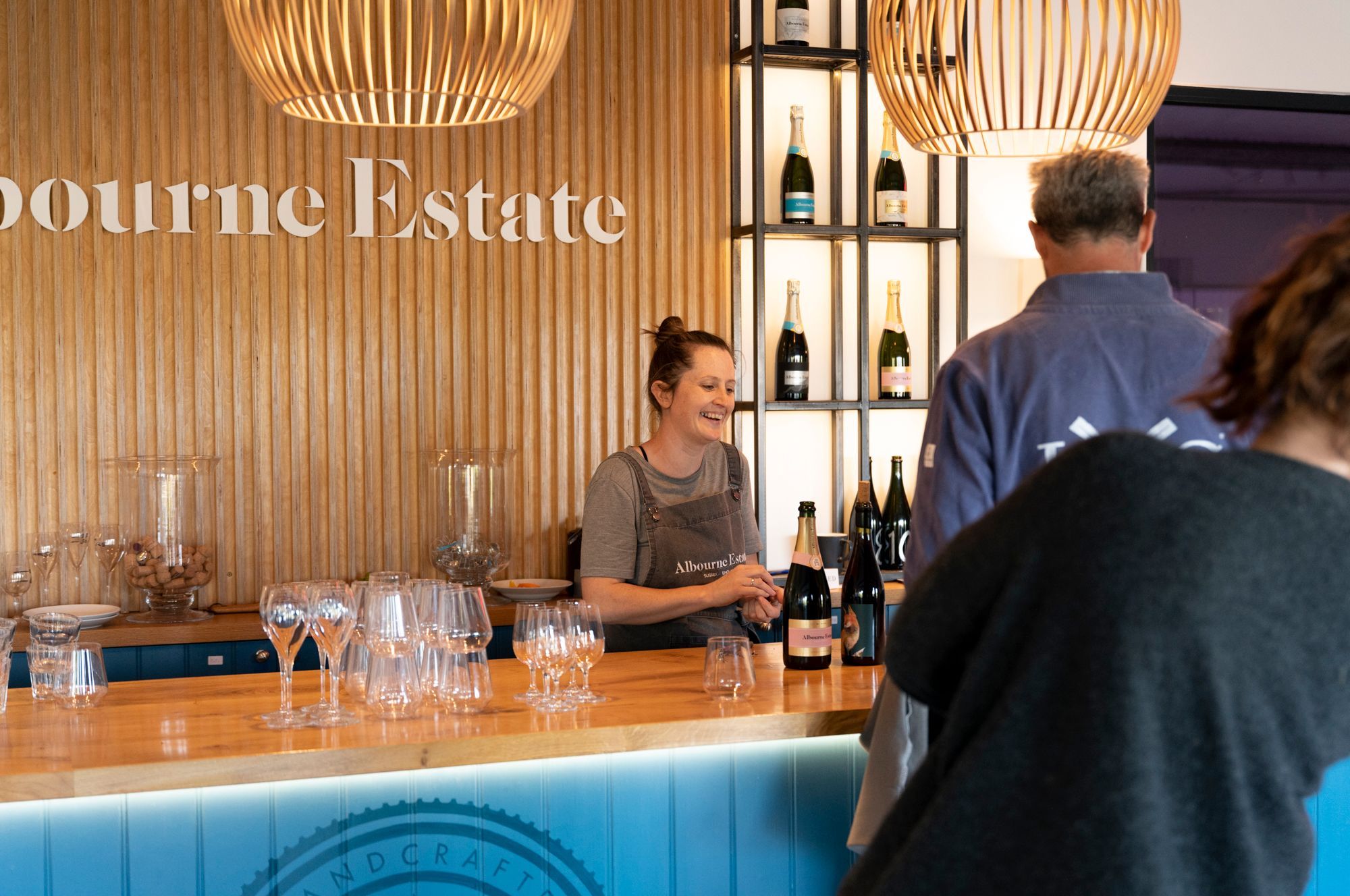 people at the Albourne Easte Tasting Room bar ordering their wine