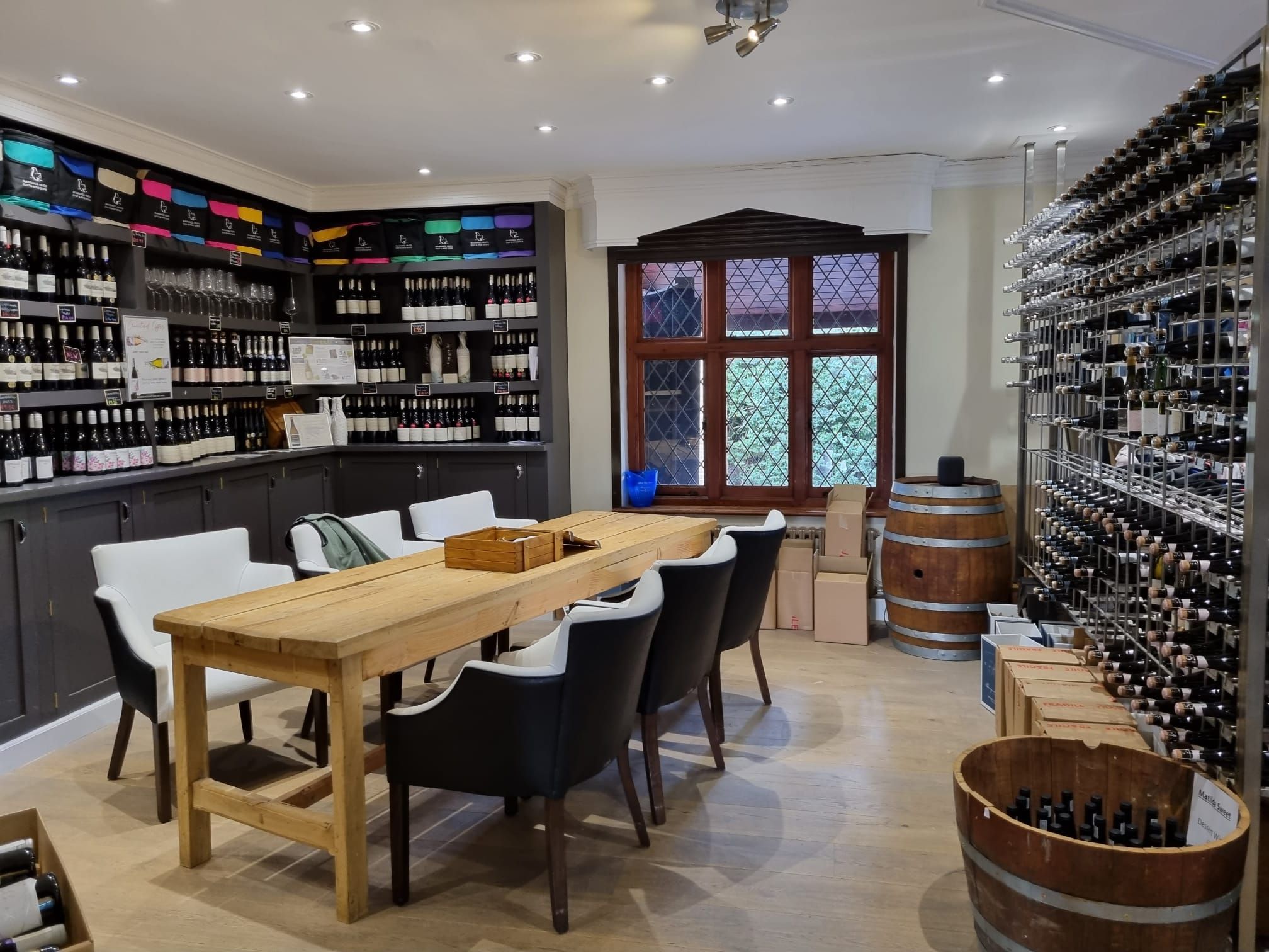 Wine tasting table. a wooden table with hundreds of wine bottles surrounding the tasting area. West Sussex Golf Club
