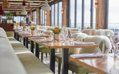 beautiful windows seating at the rockwater. Brighton seafront restaurant. Picture shows glasses on wooden table with cutlery and napkins. Part of the Brighton Fish and Chips guide