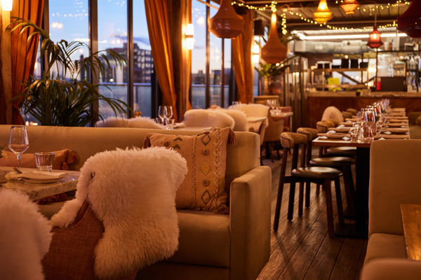 Restaurant dining room at sunset with warm tones and textures on the seating.