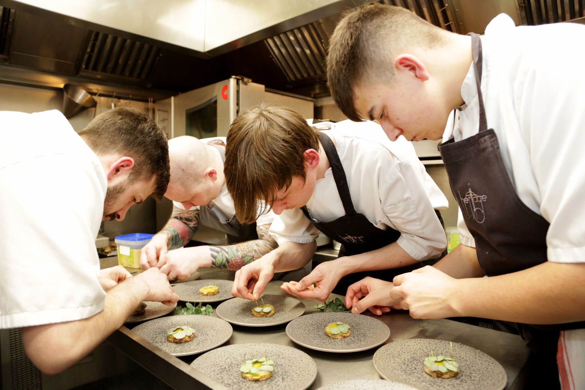 four chefs decorating dishes