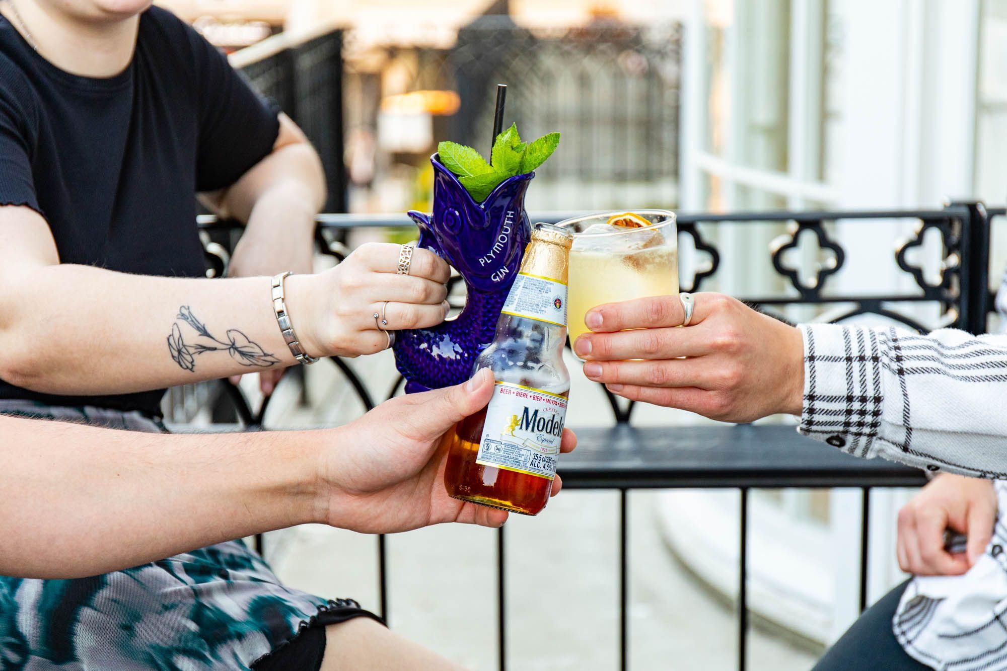 three people having a toast with their cocktails at Bar Valentino terrace