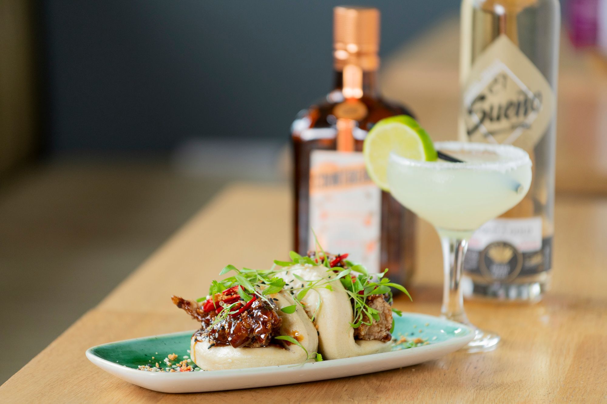 two bao buns on the light blue table served with martini at The Stirling Arms