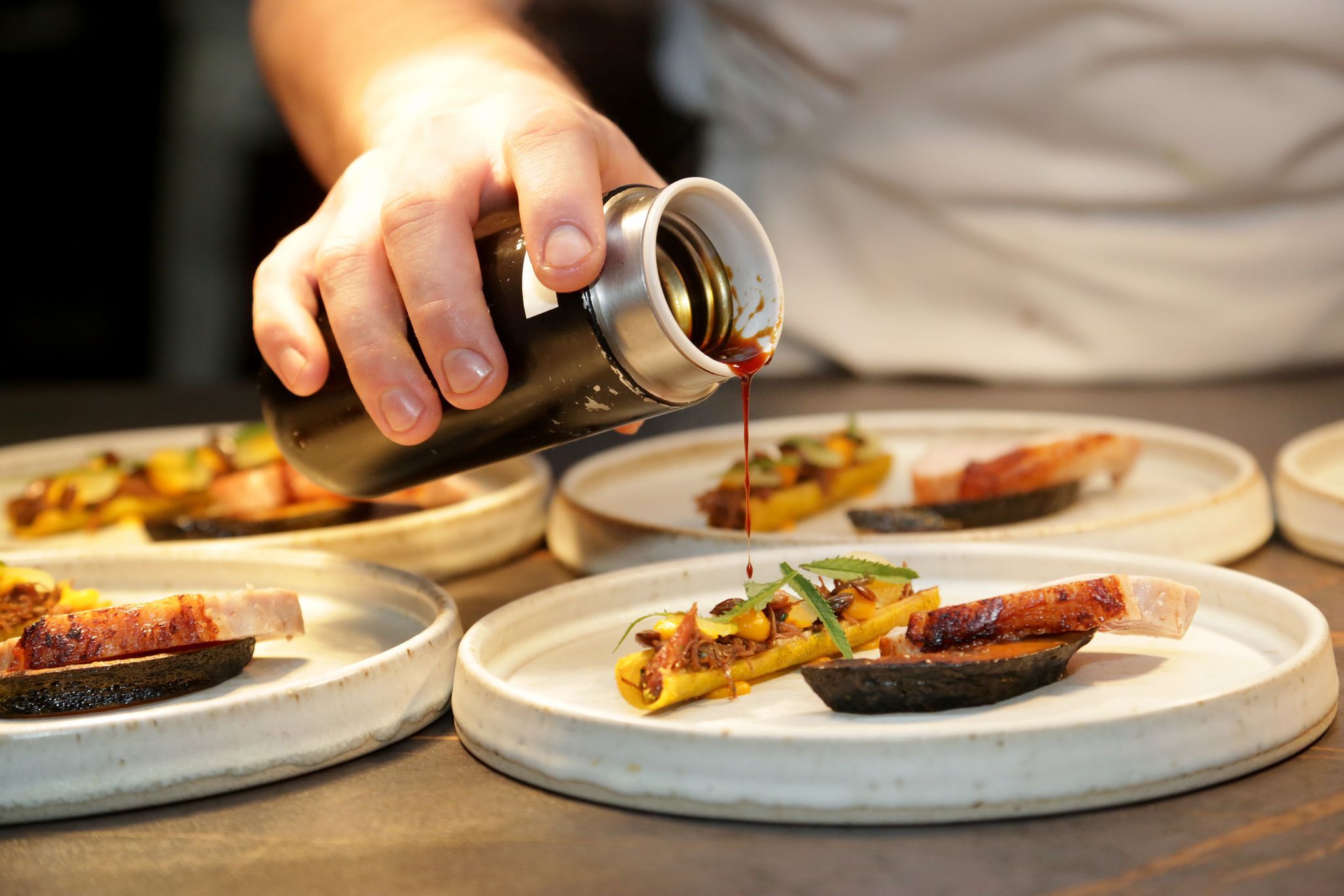 chef pouring sauce on the dish