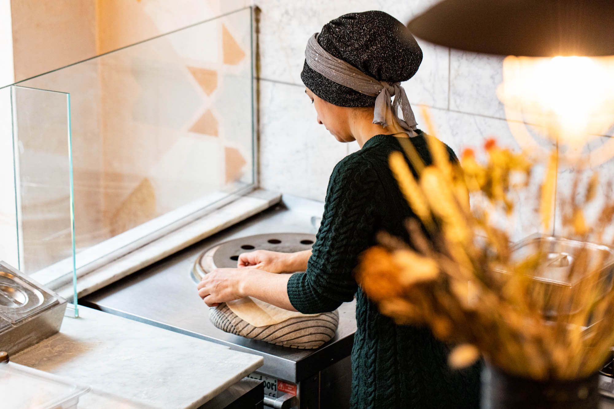woman with the scarf over head making dough at the Lavash