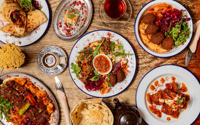 over head shot of the wooden table at lavash laid our with various middle eastern dishes