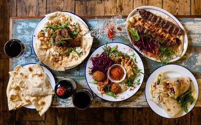 over head shot of the five different colourful dishes served at the table of Middle Eastern restaurant Lavash. Lavash serves flatbread which is an alternative to a sandwich shop in Brighton