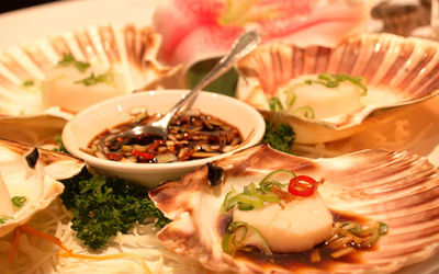 steamed scallops in the shell served in white plate