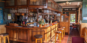 interior of the The Cricketers pub in Worthing, wooden bar are, wooden chairs and tables