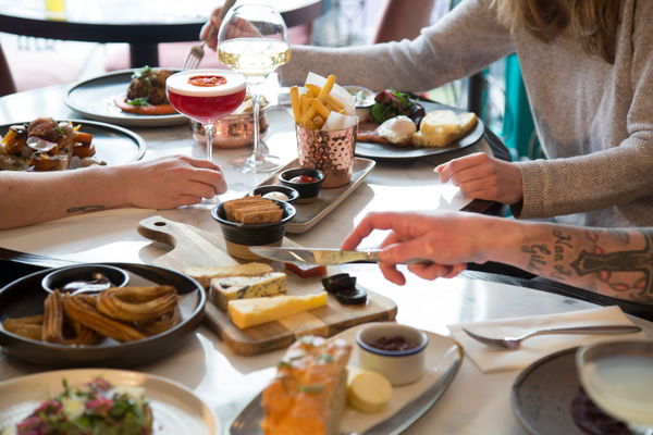 side shot of the table laid out with small plates and cocktails at Brighton Cocktail Company. A Fringe food guide favourite