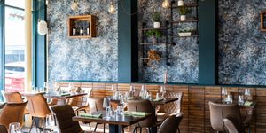 beautiful interior at the new restaurant Carne Hove, brown tables and chairs, dark green walls with wine shelves