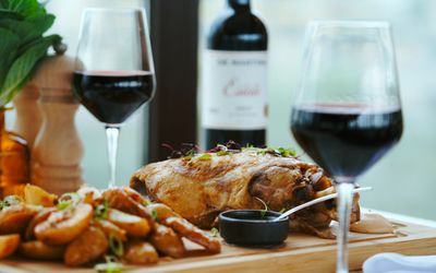 Sunday lunch served on the wooden board with two glasses of red wine