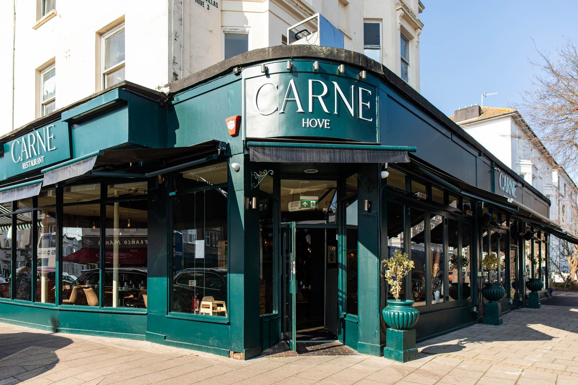 exterior shot of the Hove restaurant Carne, dark green walls with white Carne letters