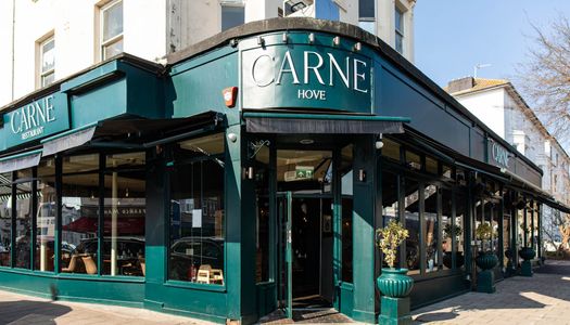 exterior shot of the Hove restaurant Carne, dark green walls with white Carne letters