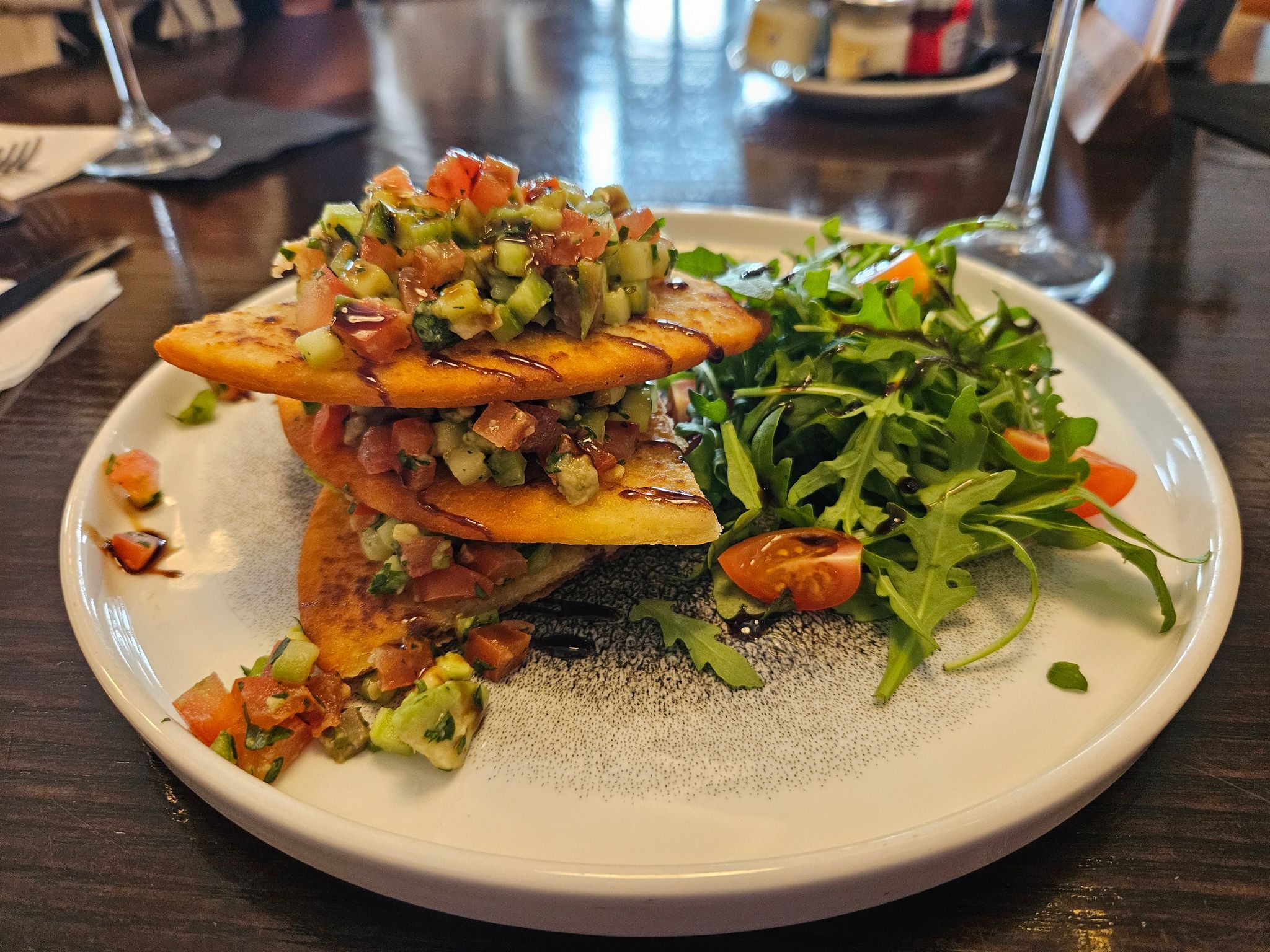 three flatbread-style scones stacked with fresh avocado, zesty salsa, and a rocket salad, served as a part of drag queen brunch menu