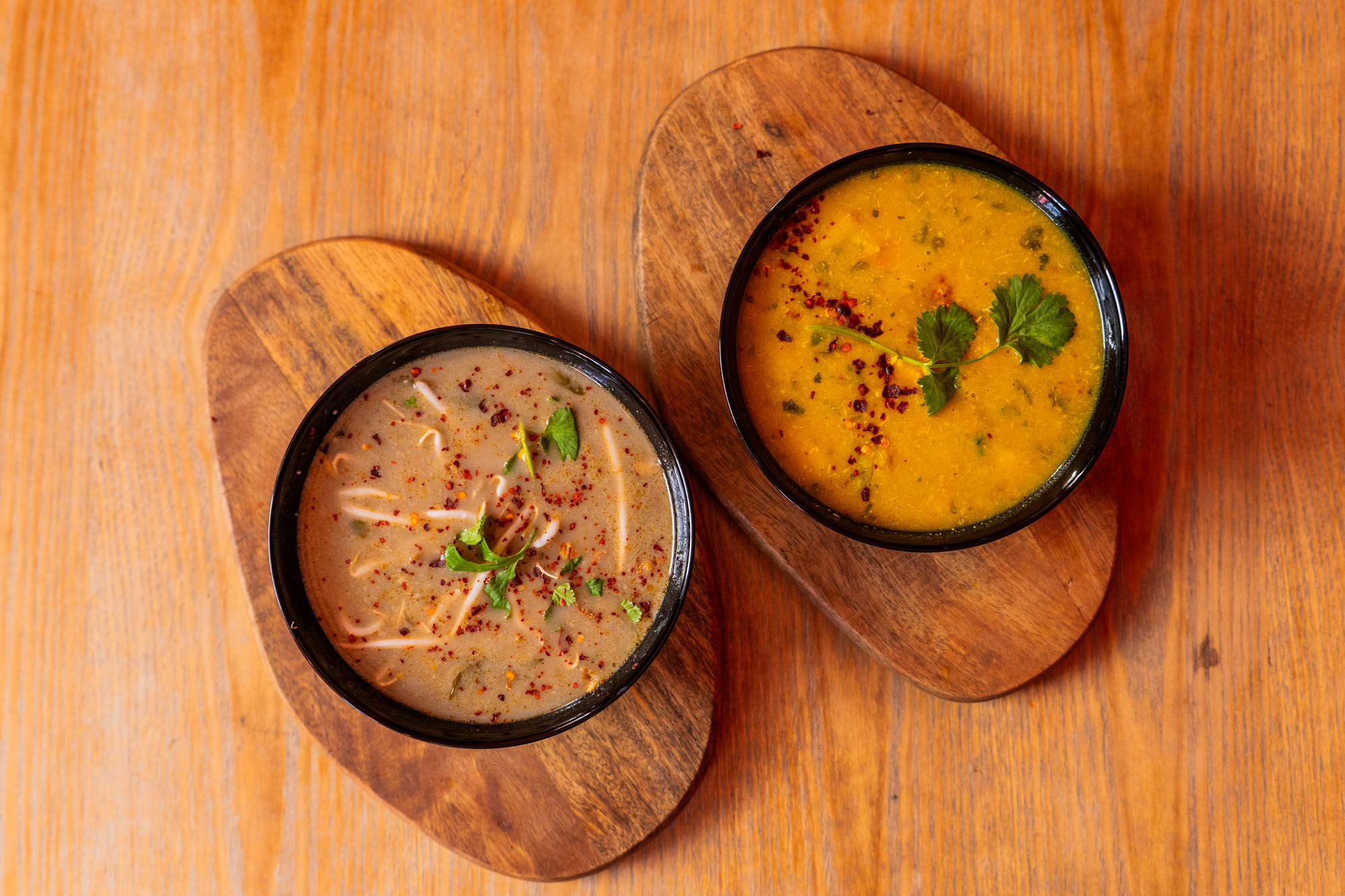 over head shot of two soup served on the wooden table