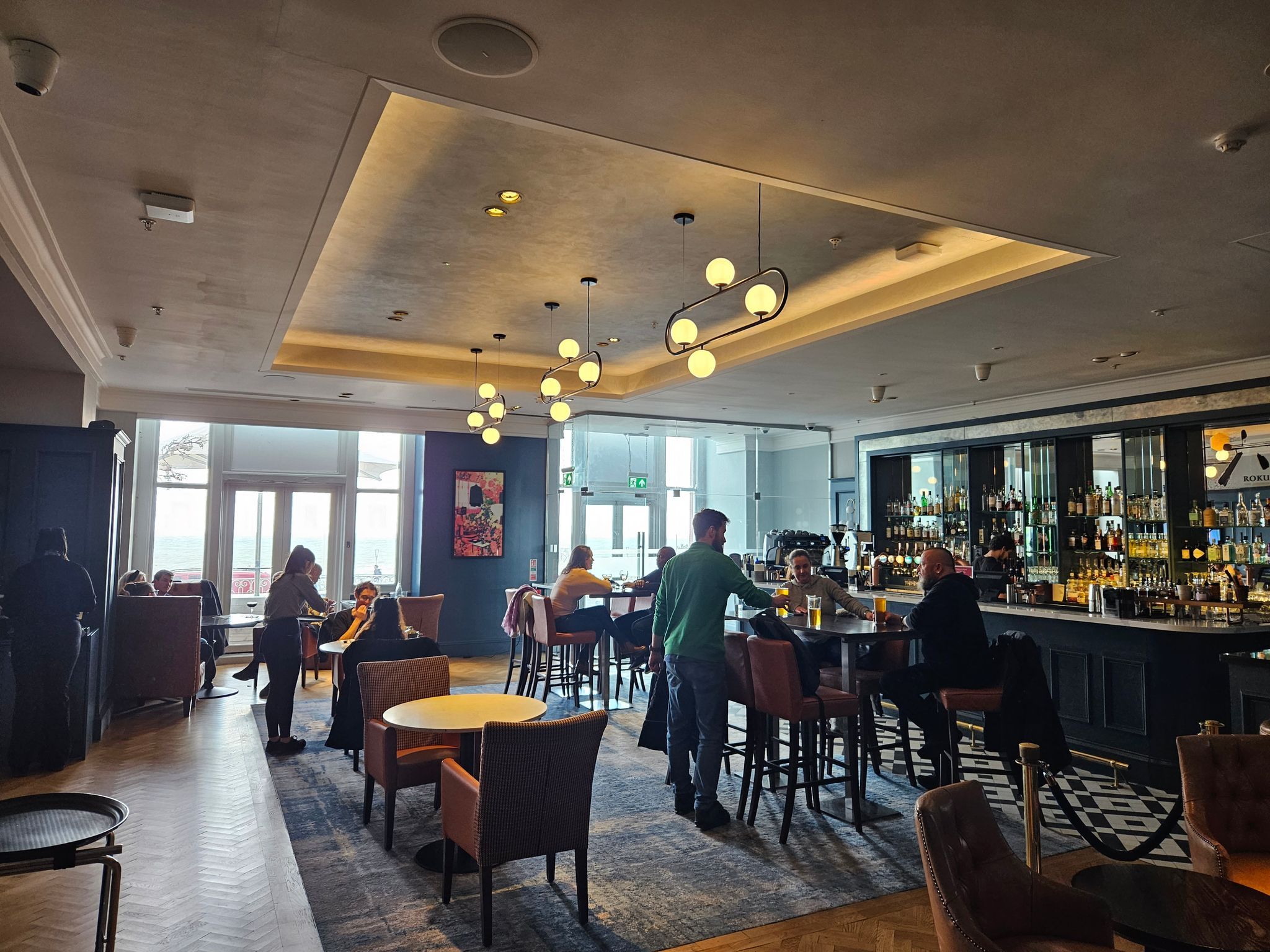 interior shot of the Brighton Metropole Bar, people by the tables having drinks 