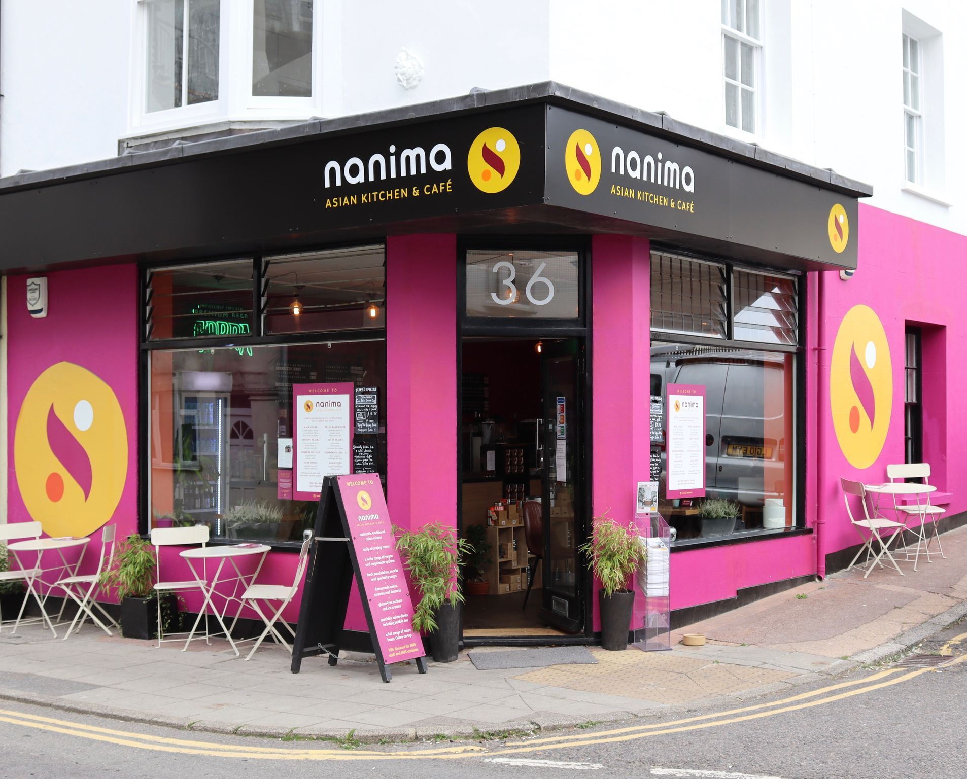 exterior shot of the Nanima Brighton, pink and black walls and chairs and tables as a part of outdoor seating