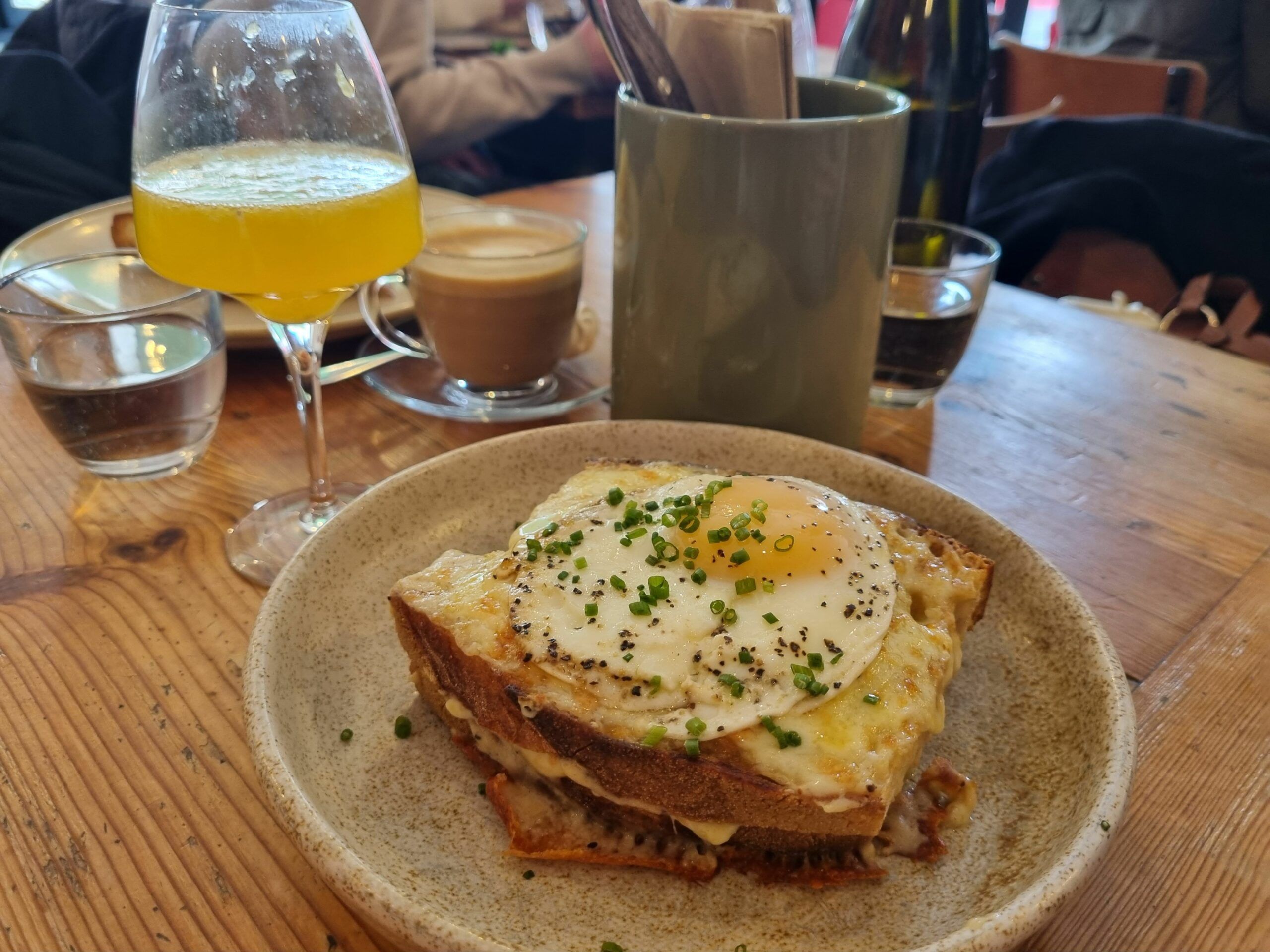 French “Le grand” croque monsieur served on grey plate on the wooden table and with mimosa