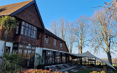 The exterior of Tottington Manor on a sunny winter day with a clear blu sky and sun shining on the building.