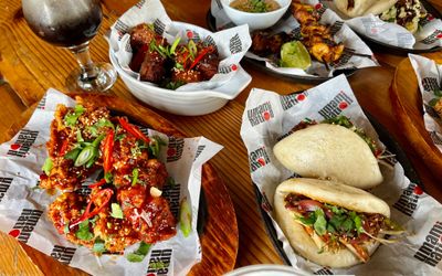 over head shot of the new kitchen concept at The Mesmerist, UmamiNation, including chicken in sauce, bao buns