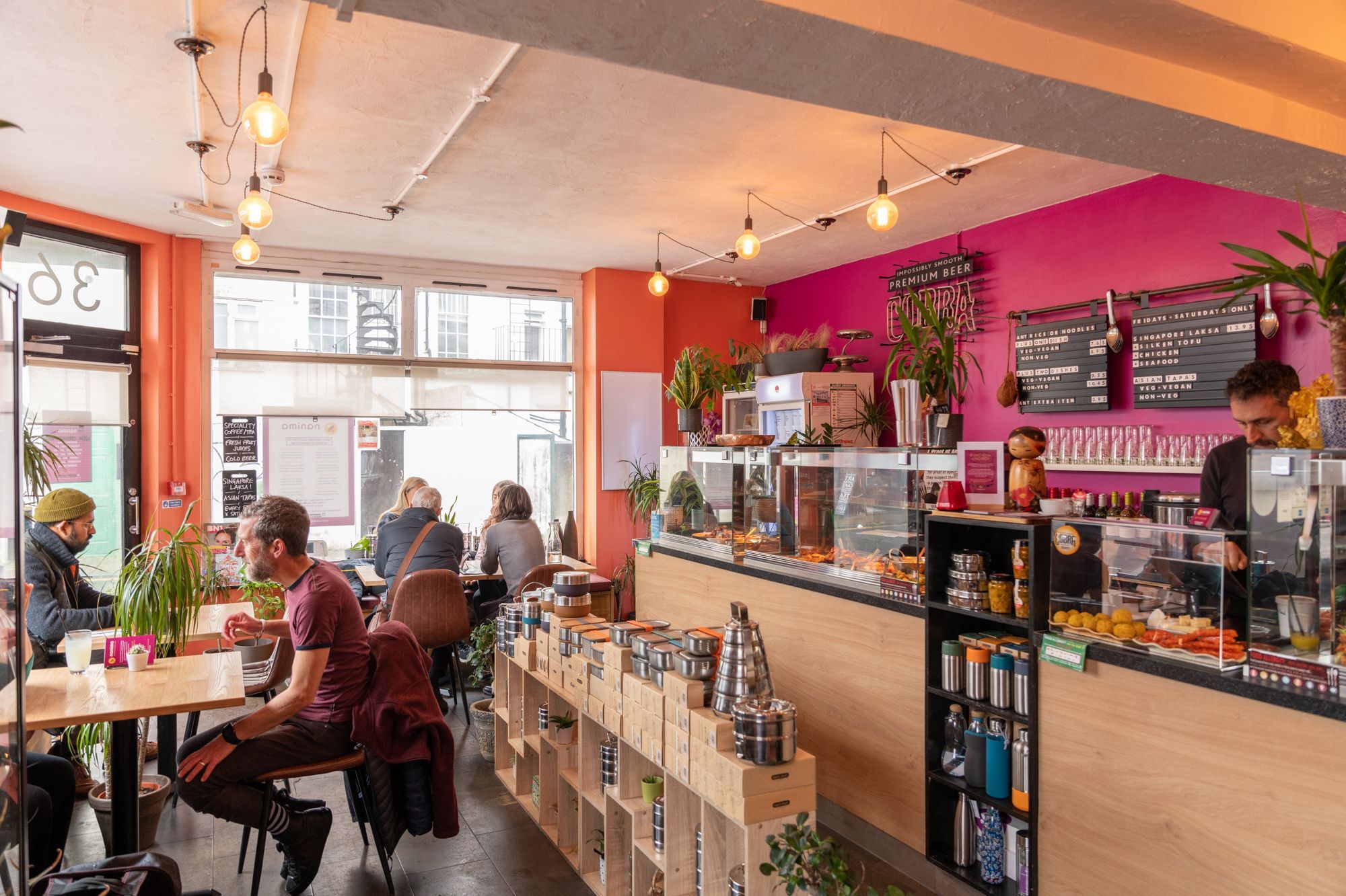 people sitting by the brown wooden tables inside the Nanima Brighton and waiting their food orders