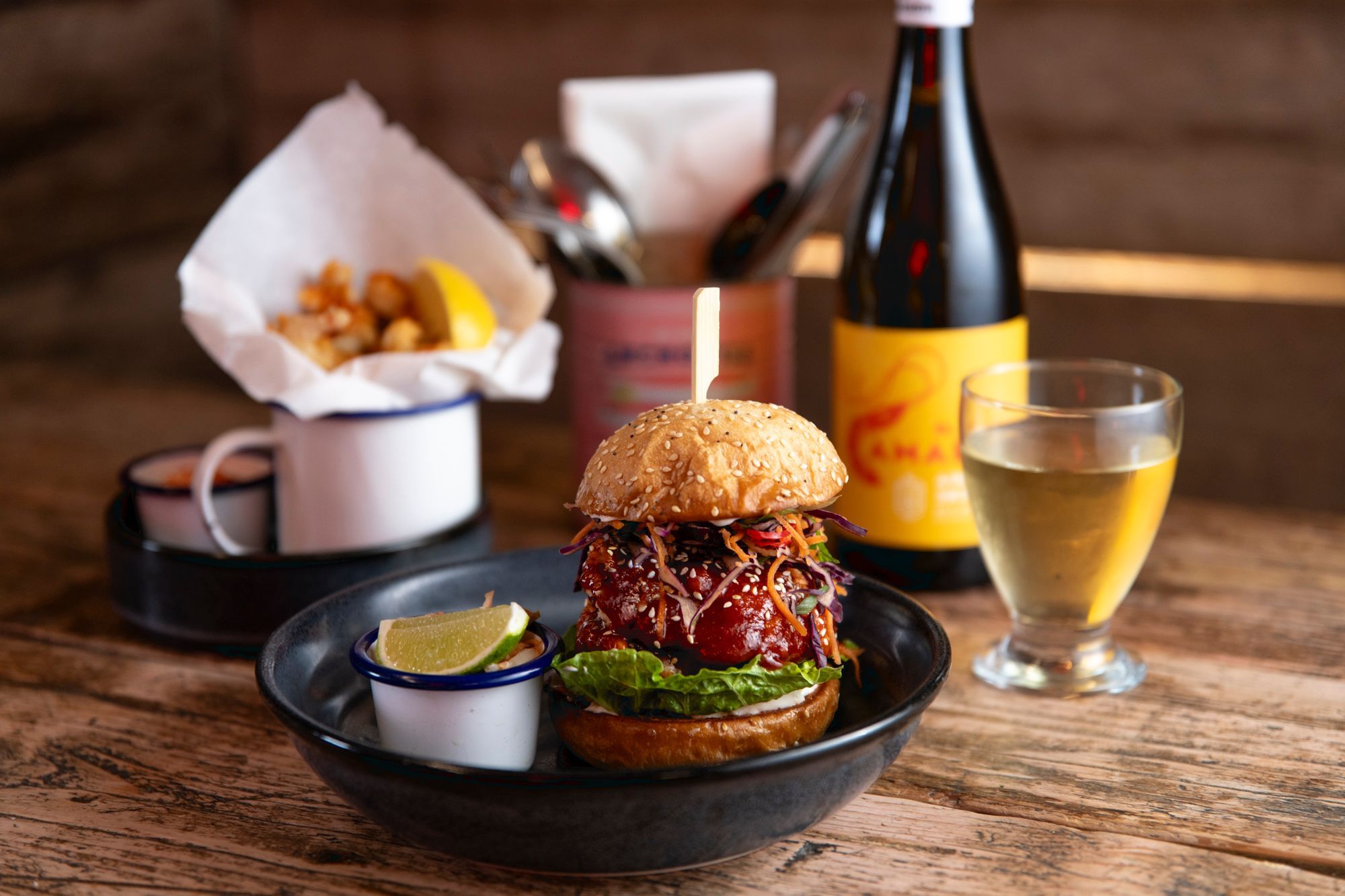 Crabshack burger served in dark plate and with glass of white wine
